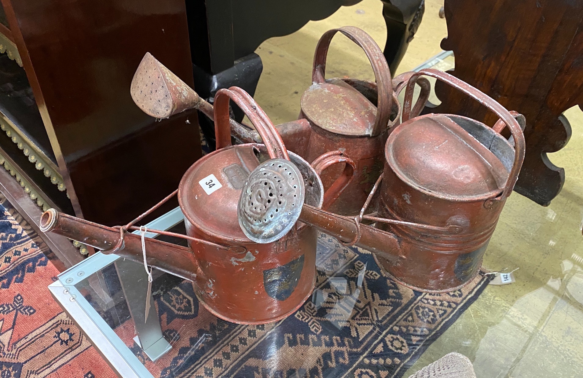 Three painted metal watering cans
